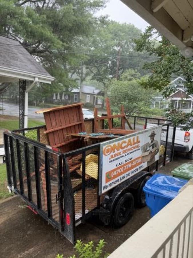 OnCall branded trailer loaded with furniture during a rainy-day curbside pickup