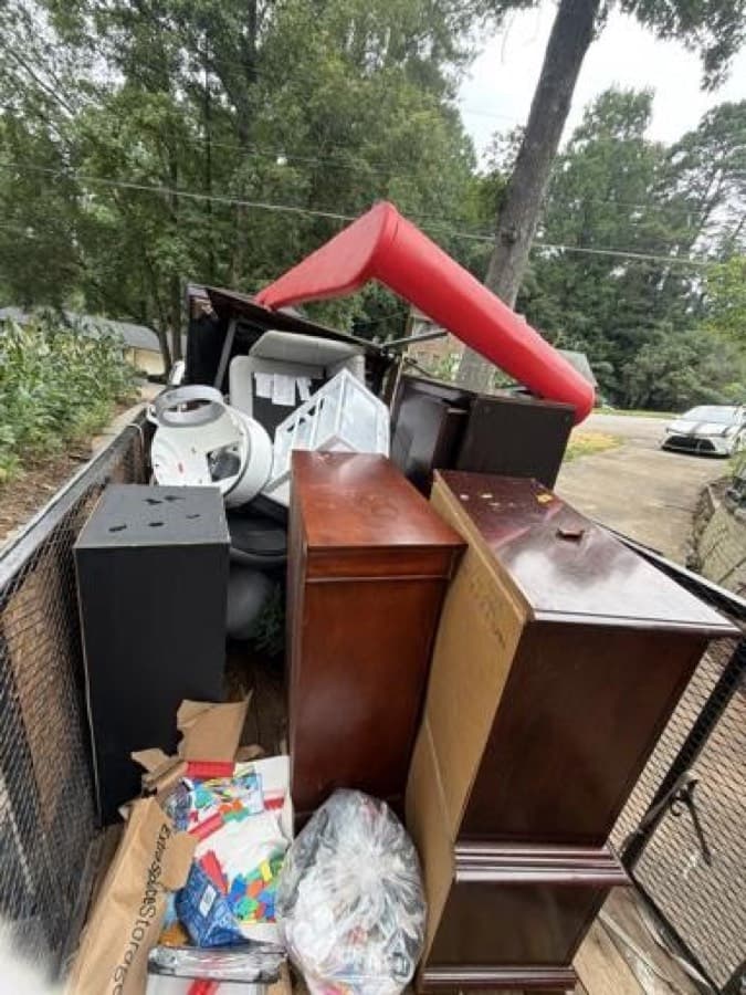 Trailer loaded with dressers, a treadmill, and furniture ready for donation drop-off